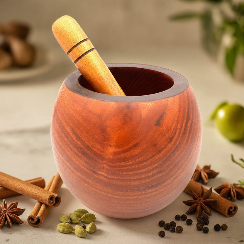 A hand-crafted rounded mortar and pestle made of sustainably harvested tropical hardwood, with a food-safe linseed oil finish, displayed on a kitchen counter.