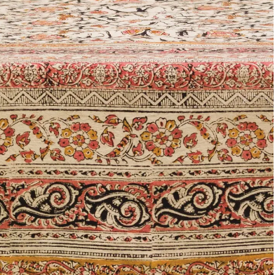Decorative fabric with intricate patterns in red, black, and gold on a beige background