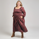 Switch Woman wearing a burgundy dress with long sleeves on a plain background 1 image
