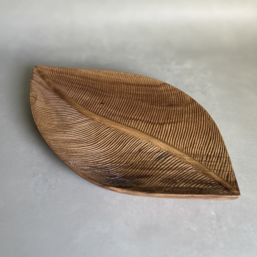 Wooden leaf-shaped object on a gray surface
