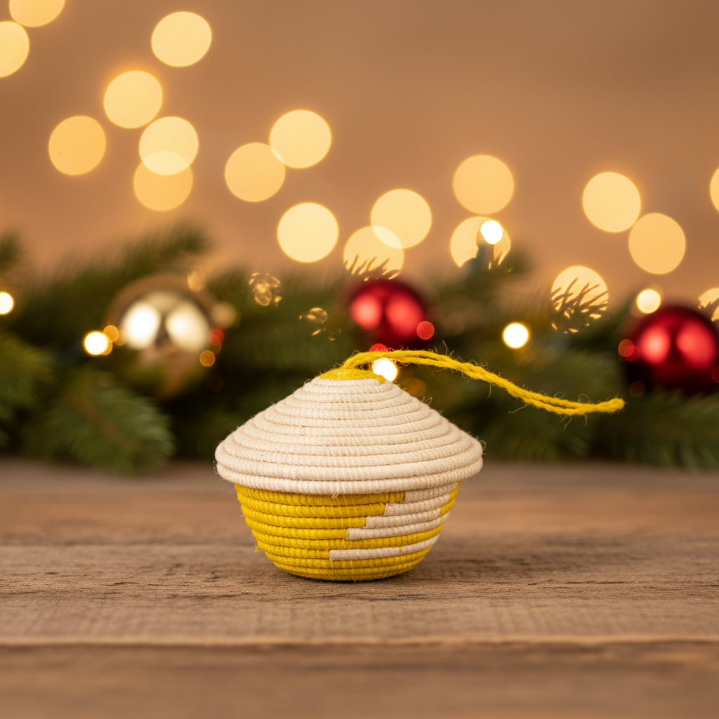 A woven miniature basket ornament in yellow and beige with a pointed lid, attached with a yellow string.