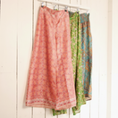 Switch Three patterned skirts hanging on a rack against a white wall. 3 image