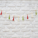 Switch String of colorful tassels against a white brick wall 2 image