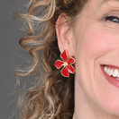 Switch Close-up of a woman wearing a red flower-shaped earring with a gray background 1 image