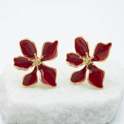 Red flower-shaped earrings with gold accents on a white background