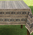 Switch Decorative tablecloth with intricate patterns on a wooden table outdoors. 3 image