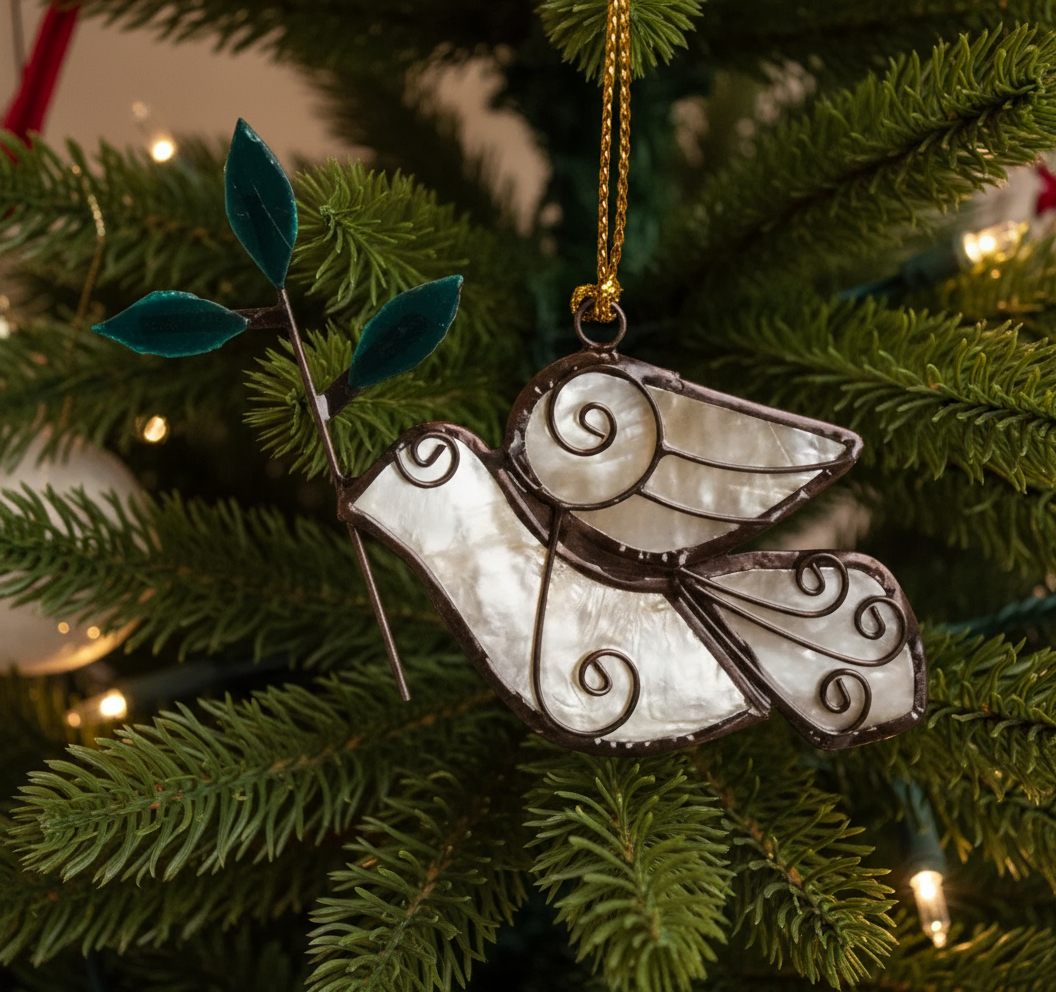 A handcrafted capiz shell ornament in the shape of a dove with an olive branch, hanging from a gold-colored chain.