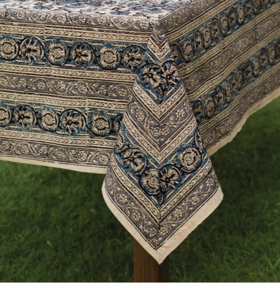 Decorative tablecloth with intricate patterns on a table outdoors.