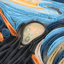 Switch Close-up of rolled-up paper strips in various colors including blue, orange, and black. 2 image