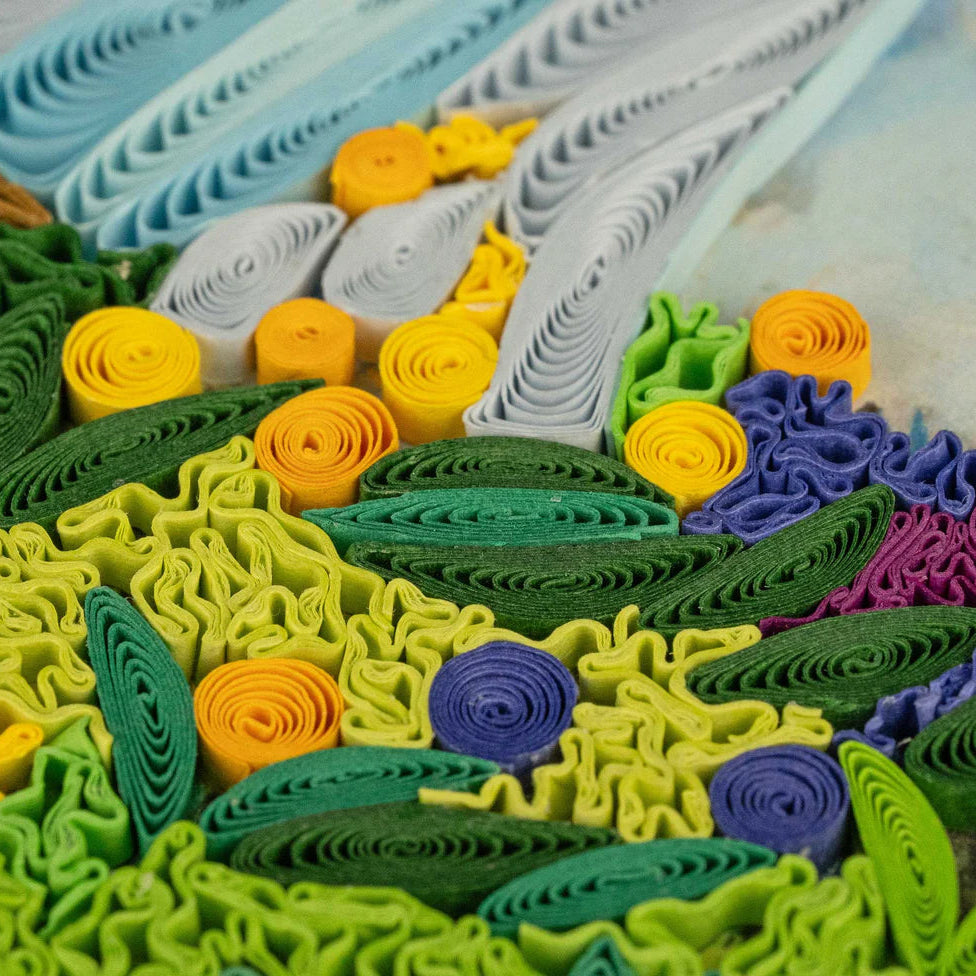 Colorful paper quilling art with green, yellow, purple, and blue patterns.