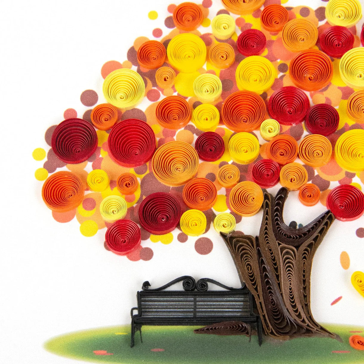 Colorful paper tree with a bench underneath on a white background