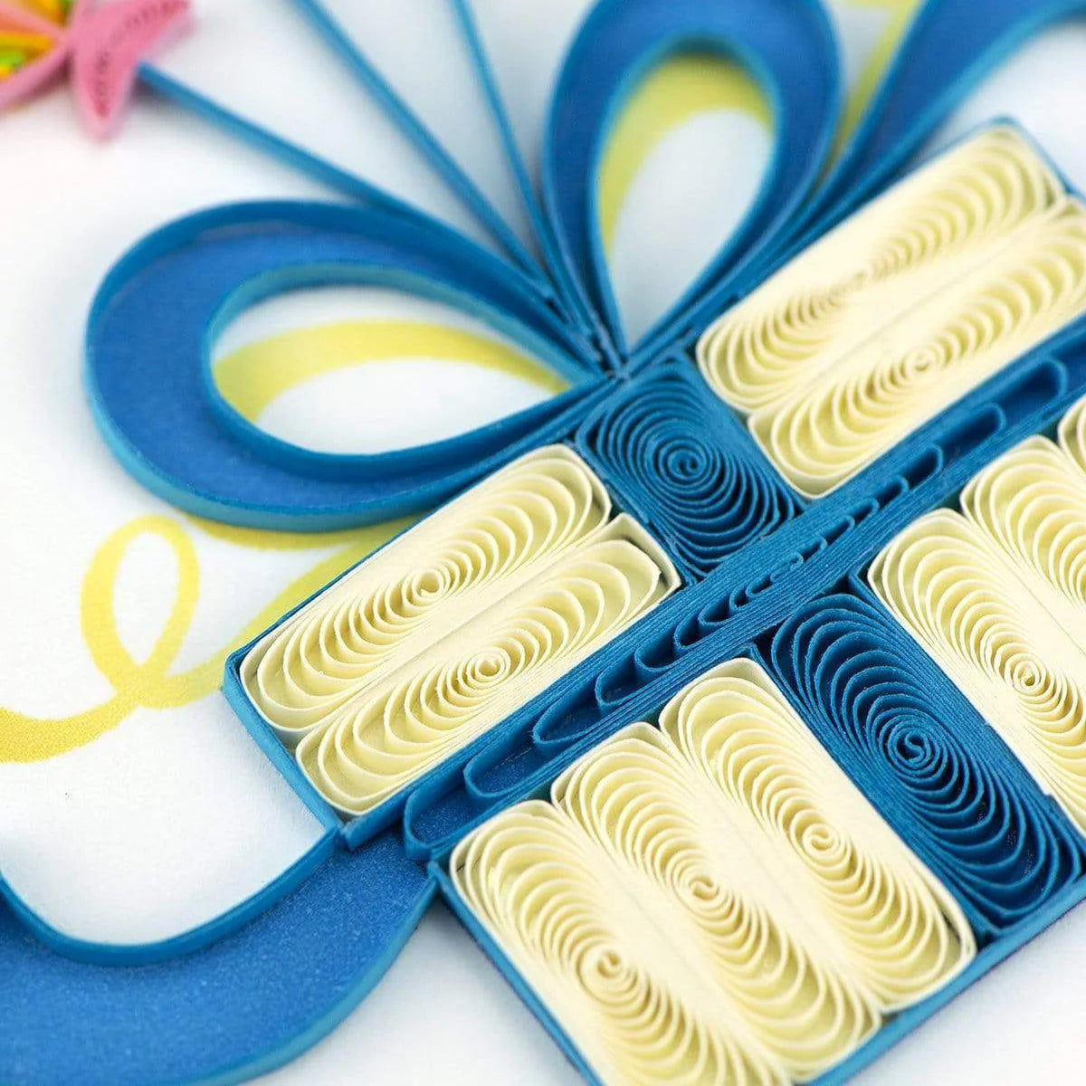 Blue and yellow paper craft with decorative elements on a white background
