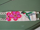 Switch Beaded bracelet with a design of a hummingbird and flower on a green surface 2 image