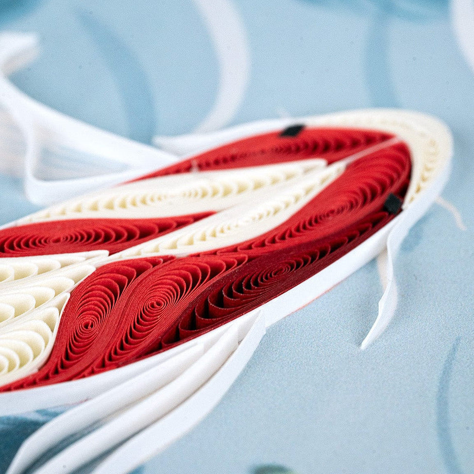 Red and white paper fish with rolled paper design on a light blue background