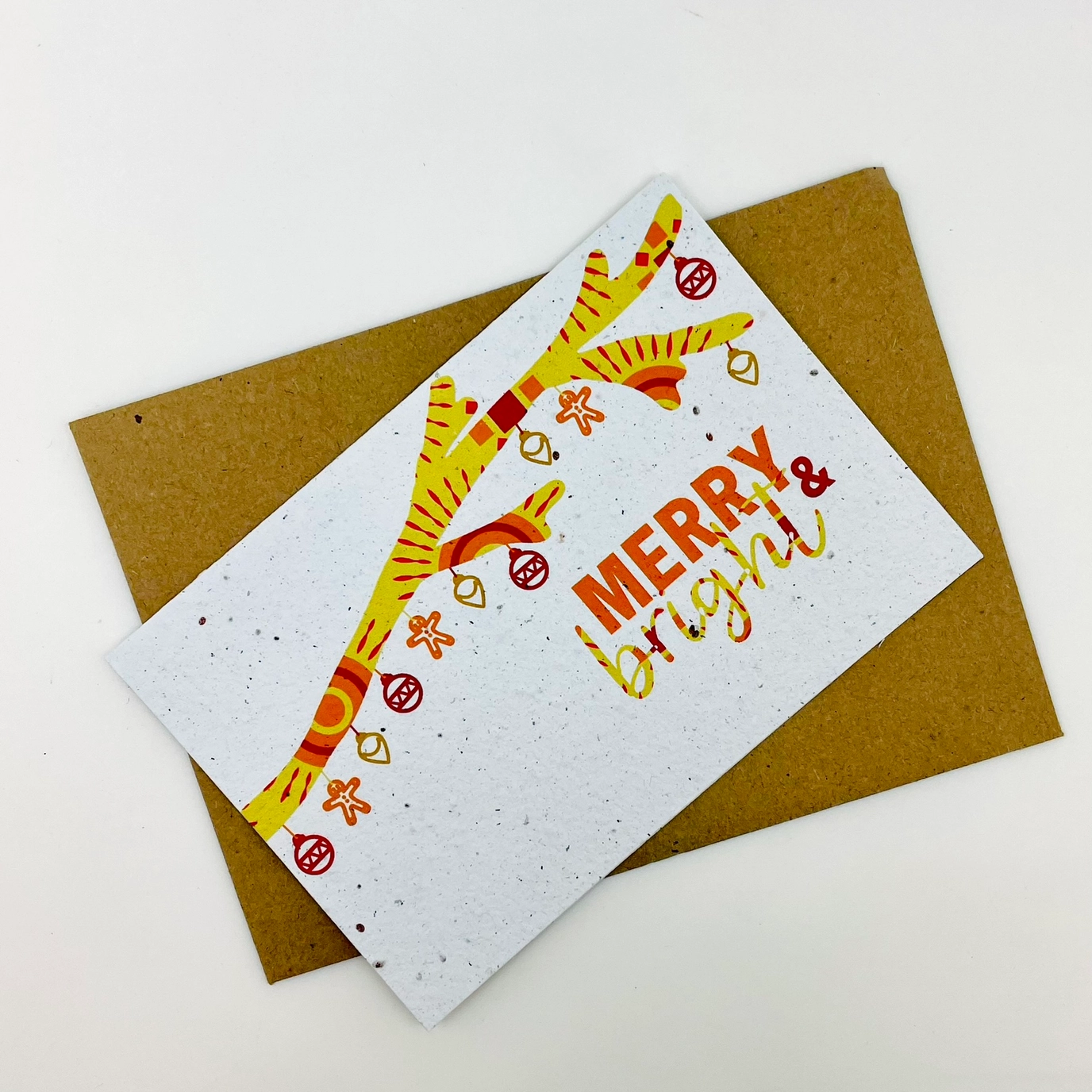 Greeting card with 'Merry & Bright' text and festive design on a brown envelope.