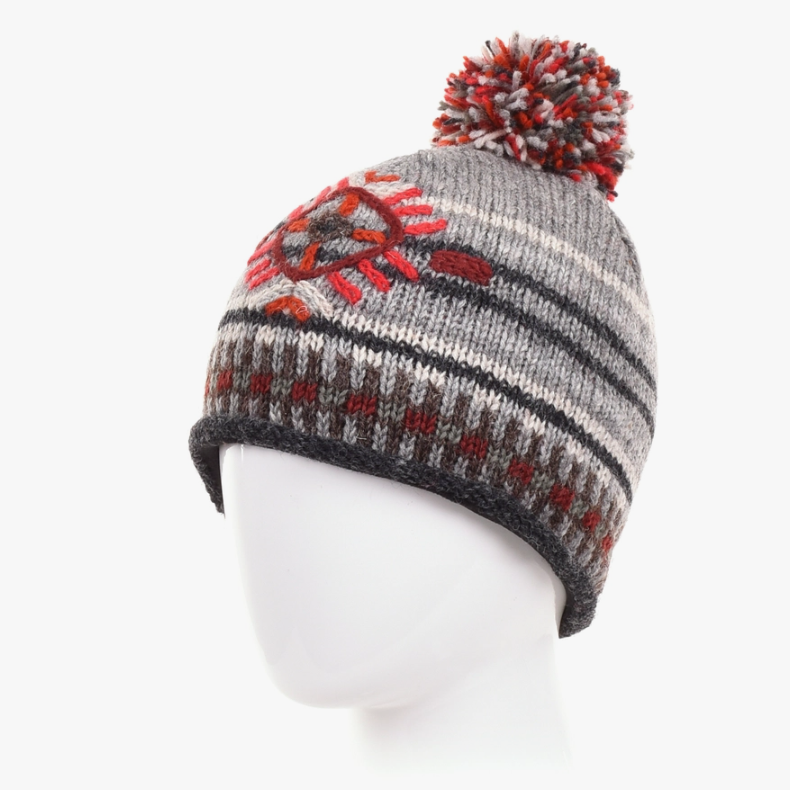 Knitted beanie with a pom-pom on a mannequin head against a white background