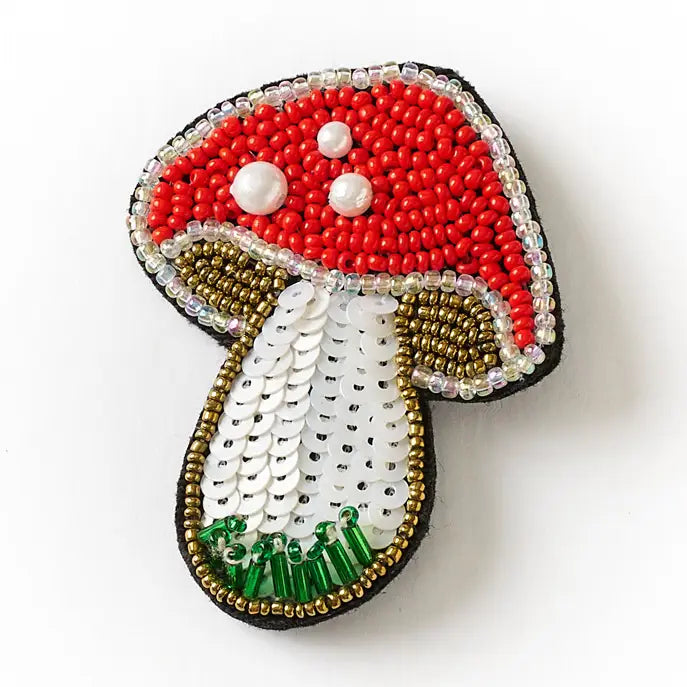 Beaded mushroom-shaped pin on a white background