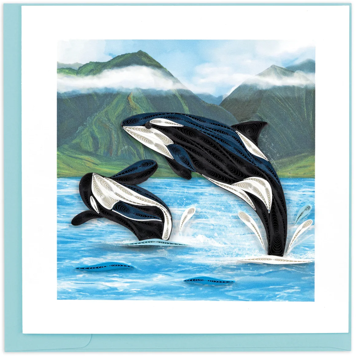 Two orcas jumping out of the water with a mountainous background