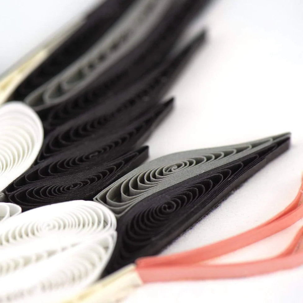 Close-up of black, white, and red folded paper on a white background