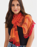 Switch Woman wearing an orange and red scarf with intricate patterns on a white background 2 image
