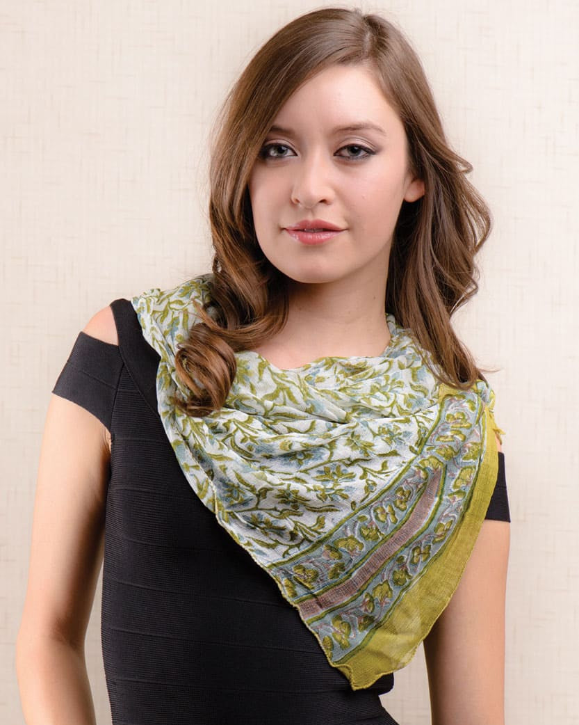 Woman wearing a green patterned scarf on a beige background