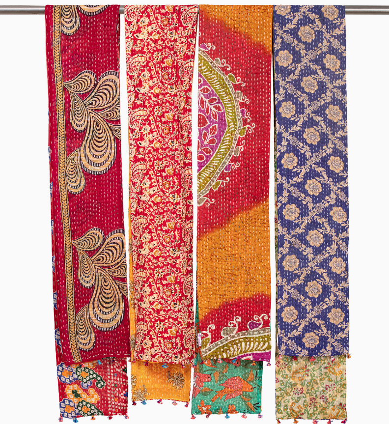 Set of colorful patterned scarves hanging on a rack.
