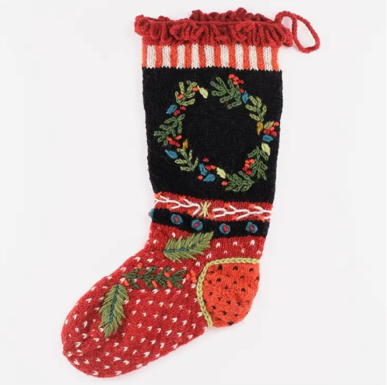 Decorative Christmas stocking with red, black, and green patterns on a white background